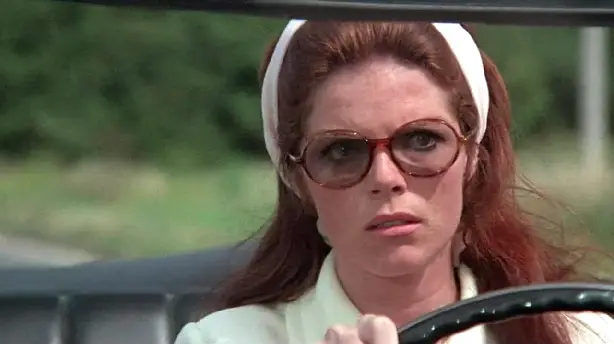 Die Dame im Auto mit Brille und Gewehr Screenshot